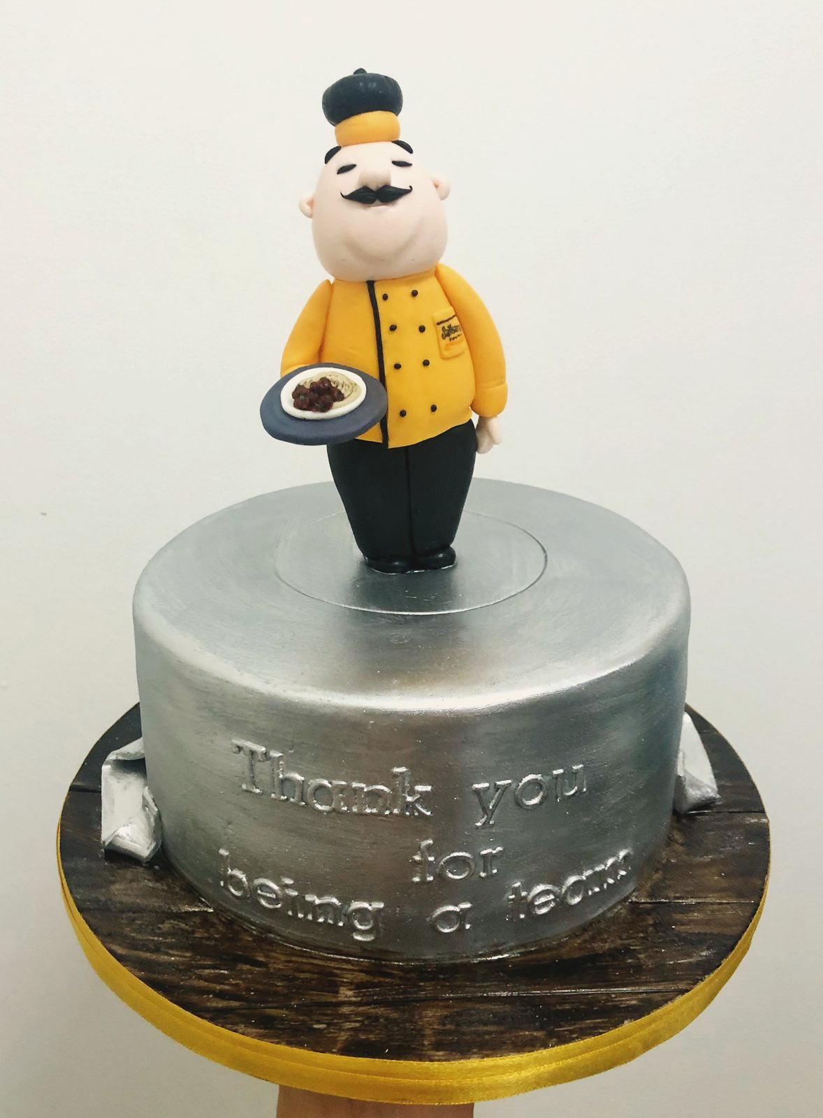 Hand-modelled chef holding a plate on a silver drum