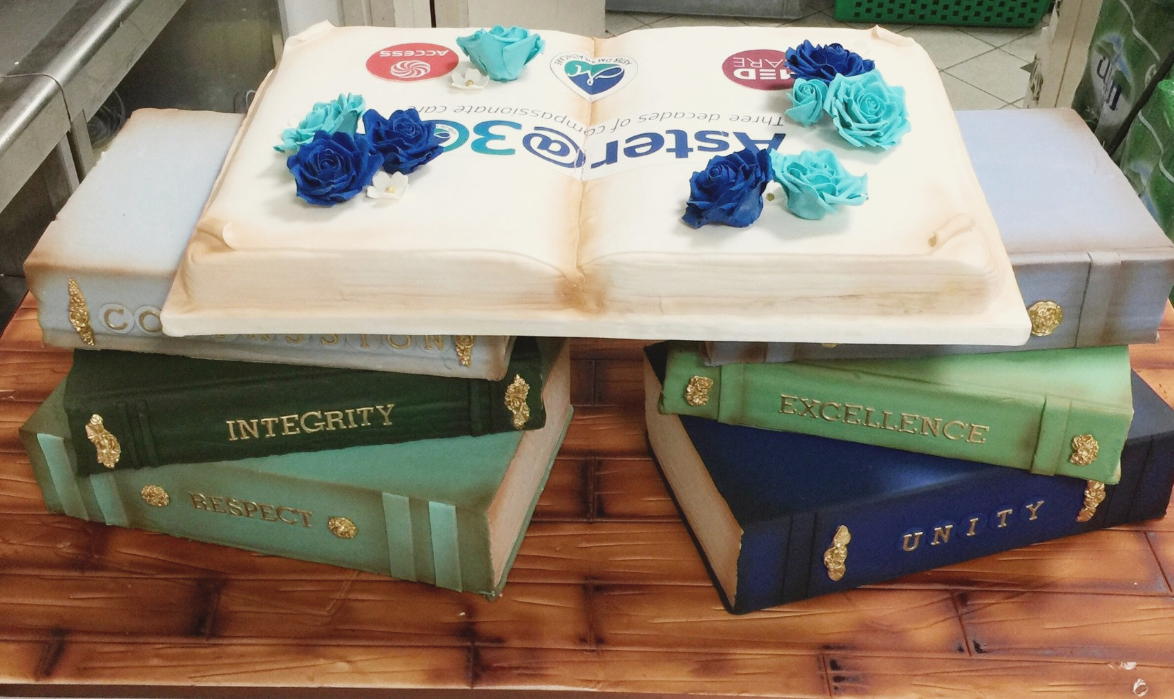 Two stacks of fondant books with an open Aster at 30 book on top